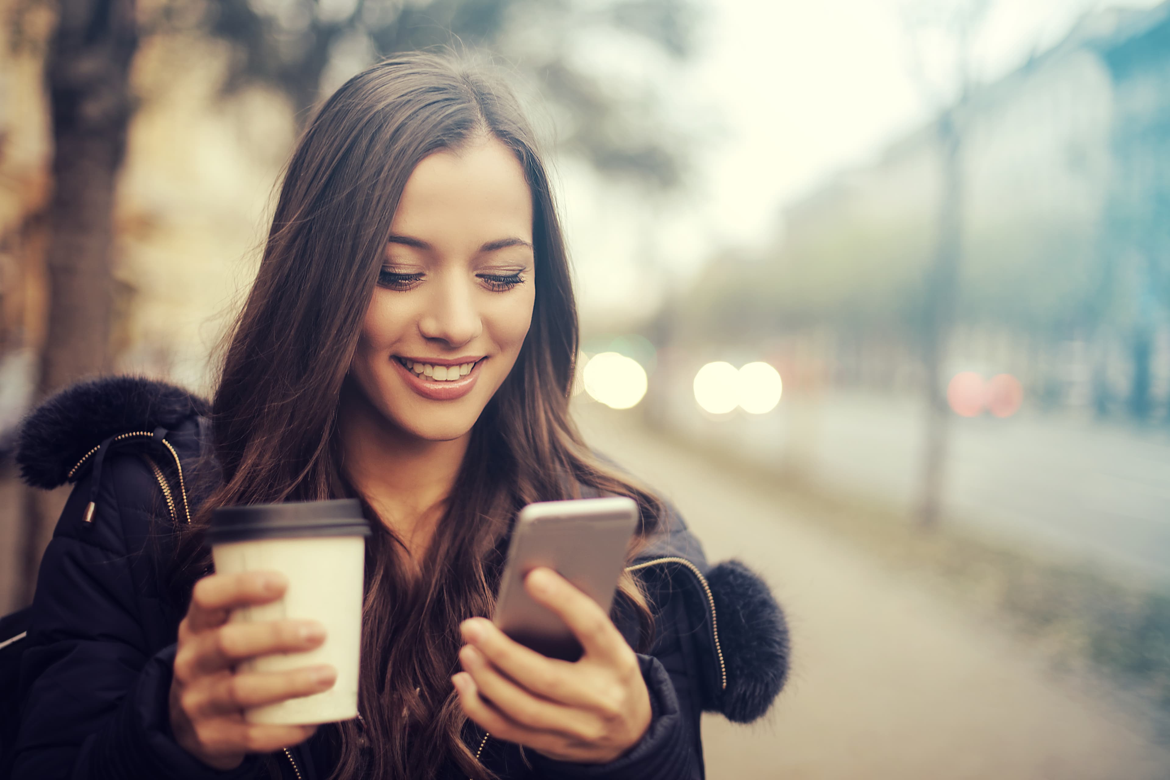 Coffee customer holding a takeaway cup and phone