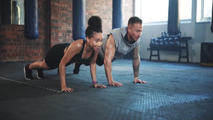 Two CRAYS members training together on the gym floor