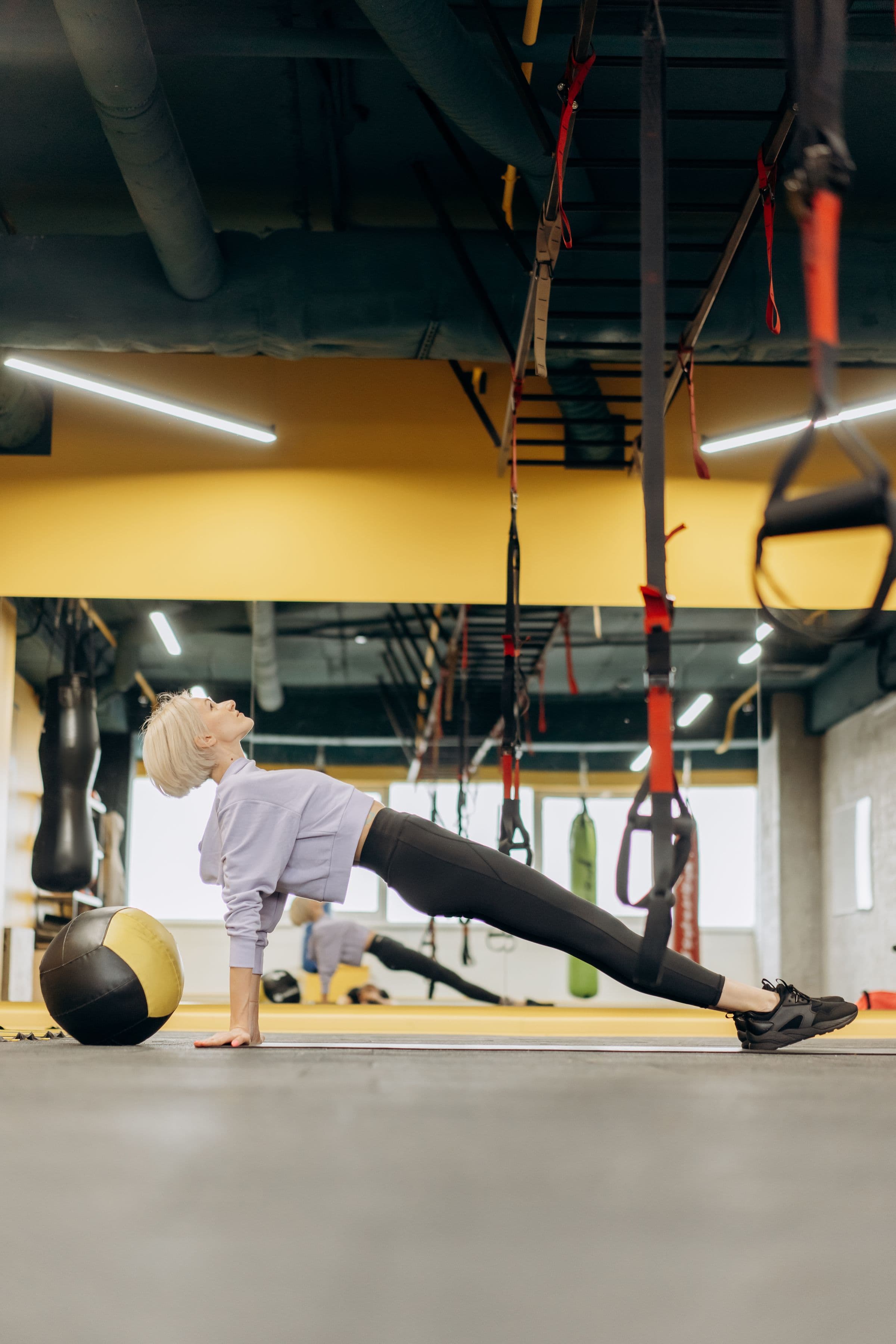 Athlete holding a controlled plank position in a bright training space