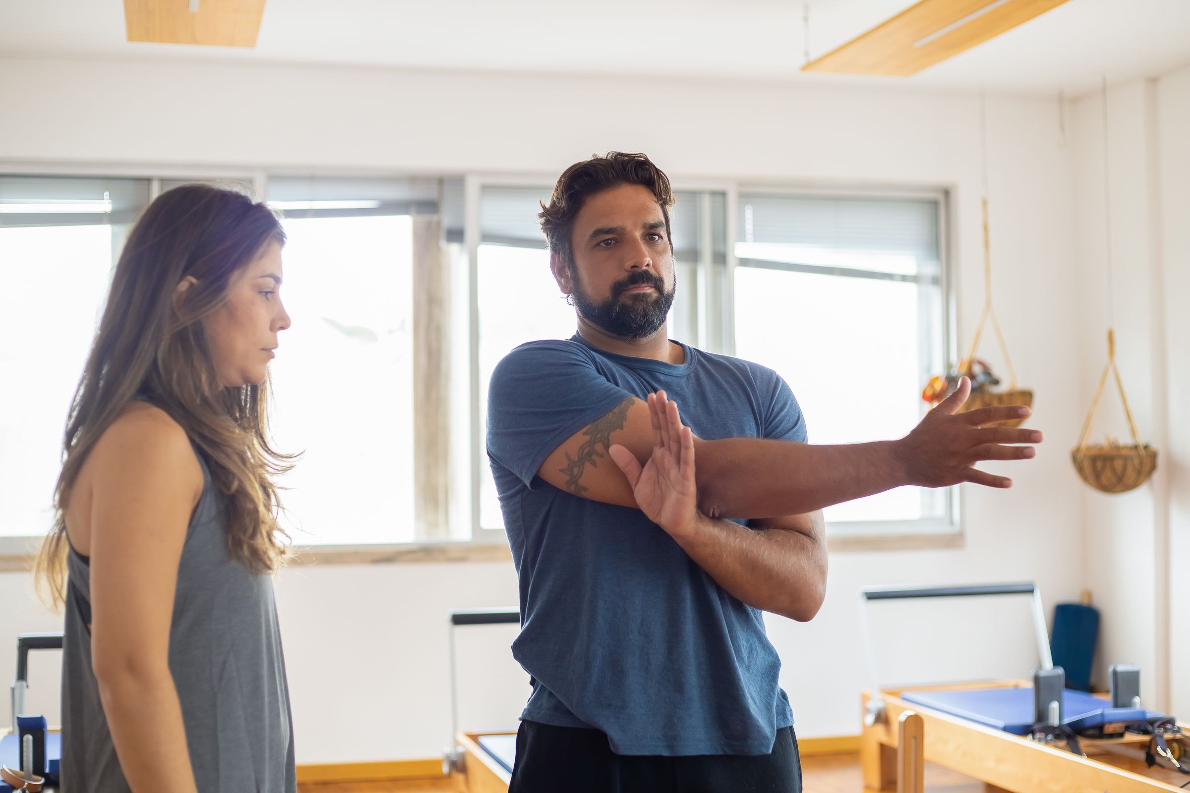 Trainer helping a member stretch in a studio